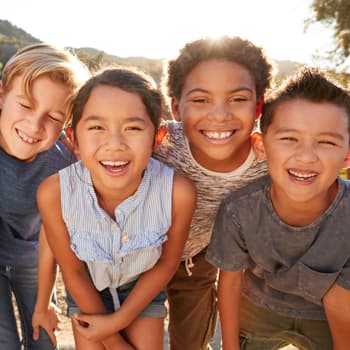 Diverse children smiling outside