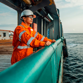 A man looking out over the railing of a boat 