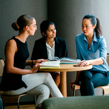 Three female Superior Energy employees sitting at a table, chatting